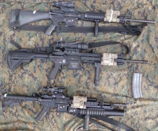 Displayed are three of the Marine Infantry squads current issue weaponry; M16A4 for riflemen, M27 for IAR gunners, and M4s with M203s for team and squad leaders. The M27 and M16A4 displayed have 3 point slings while the M4 has a 1 point. M4 and M27 have their stocks fully extended. Positioning of the laser emitting PEQ16 is up to the individual Marines discretion.