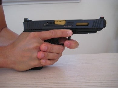 The support hand index finger pulls toward the left side of the pistol.