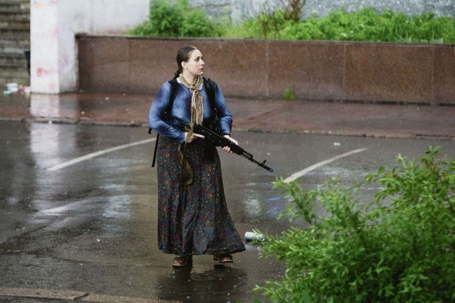 A (pro-Russian) rebel woman in besieged Slavaynsk, looks on armed with an AKS-74.