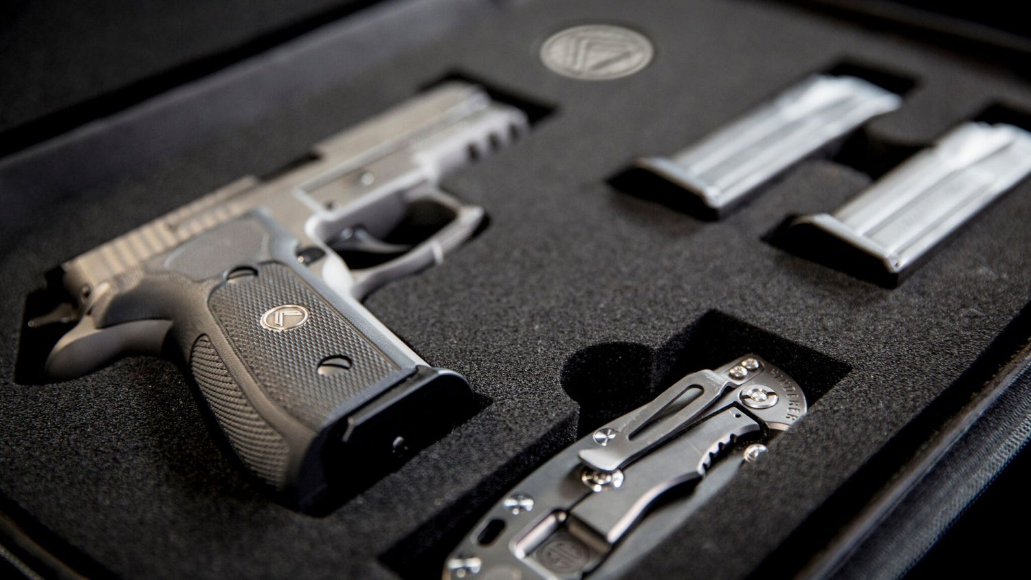The new SIG Legion P-229 in it's hard case with three mags, challenge coin and folder knife.