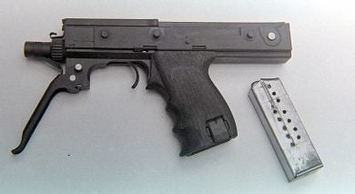 The second MPA with the 15-round magazine removed and the trigger guard extended to act as a forward grip.