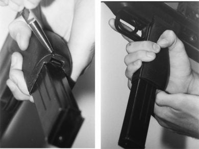 The magazine catch was a small (too small, in fact!) blade at the rear of the pistol grip that had to be pulled back to release the empty magazine. Eventual productions guns would, of course, have this hindrance dealt with.