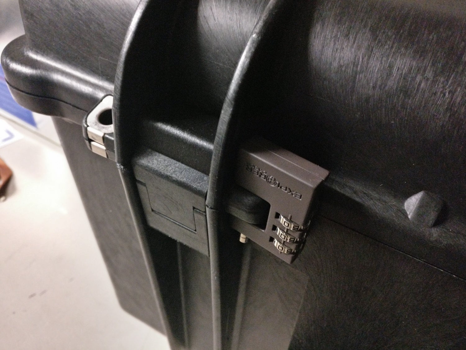 Black combination padlock affixed to a plastic hasp