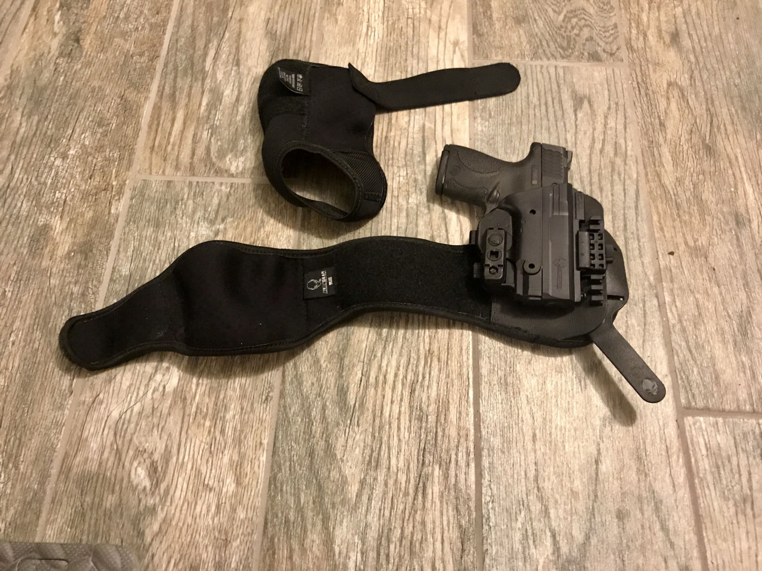 The lower wrap on top, the upper wrap with my M&P Shield. Note the “spine” on the lower right of the holster, complete with little alien head.