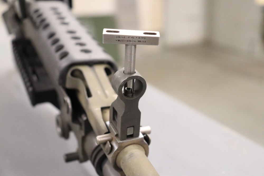 A close-up of an M249 sight adjustment tool